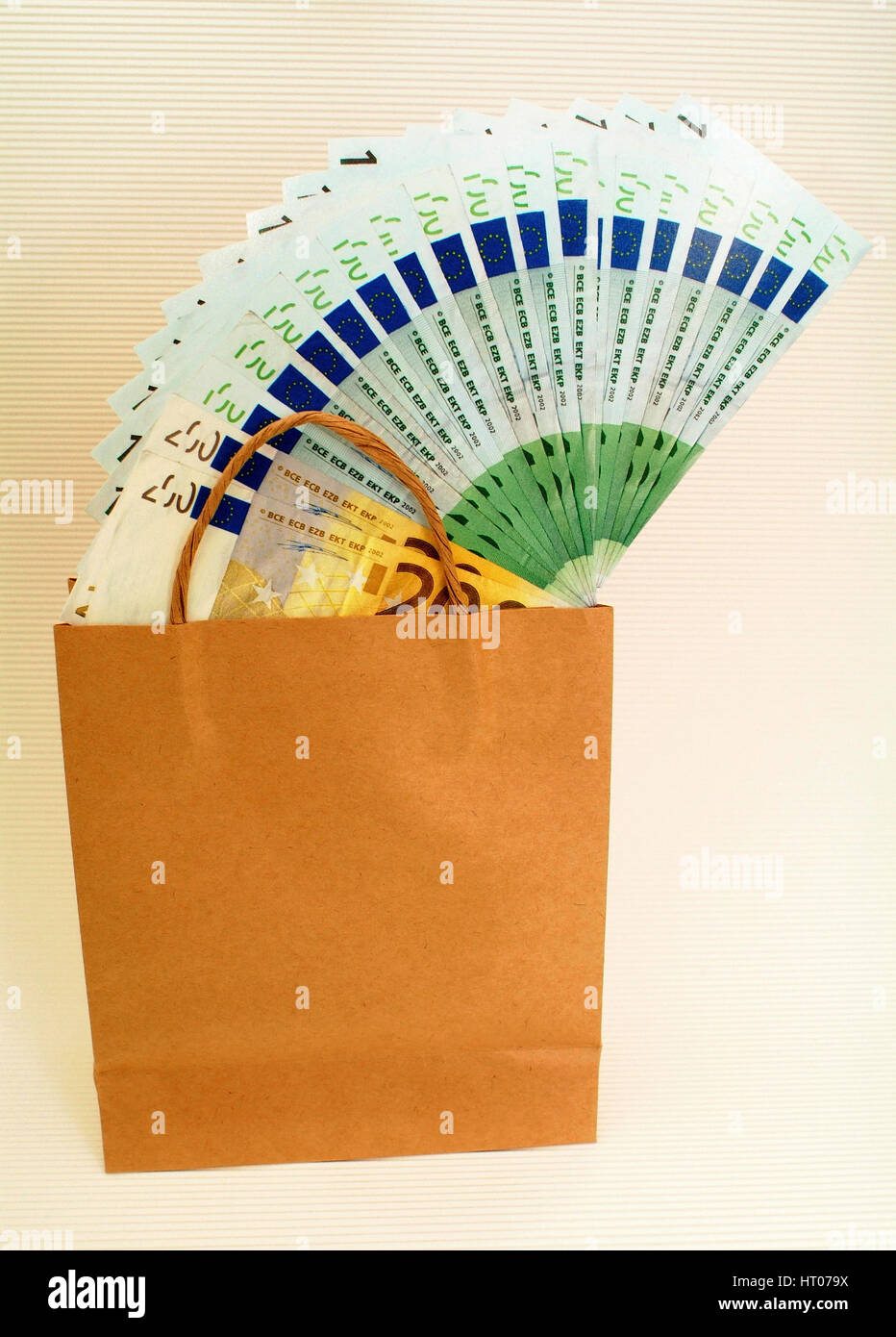 Symbolbild Geld ausgeben beim Einkauf, Papiertuete mit Geld - symbolic for expensive shopping Stock Photo