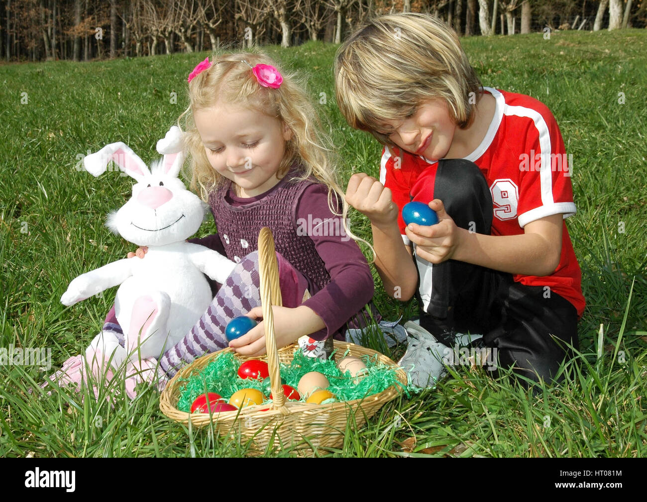 Zwei Kinder mit Osternest in der Wiese - children with Easter nest in meadow Stock Photo