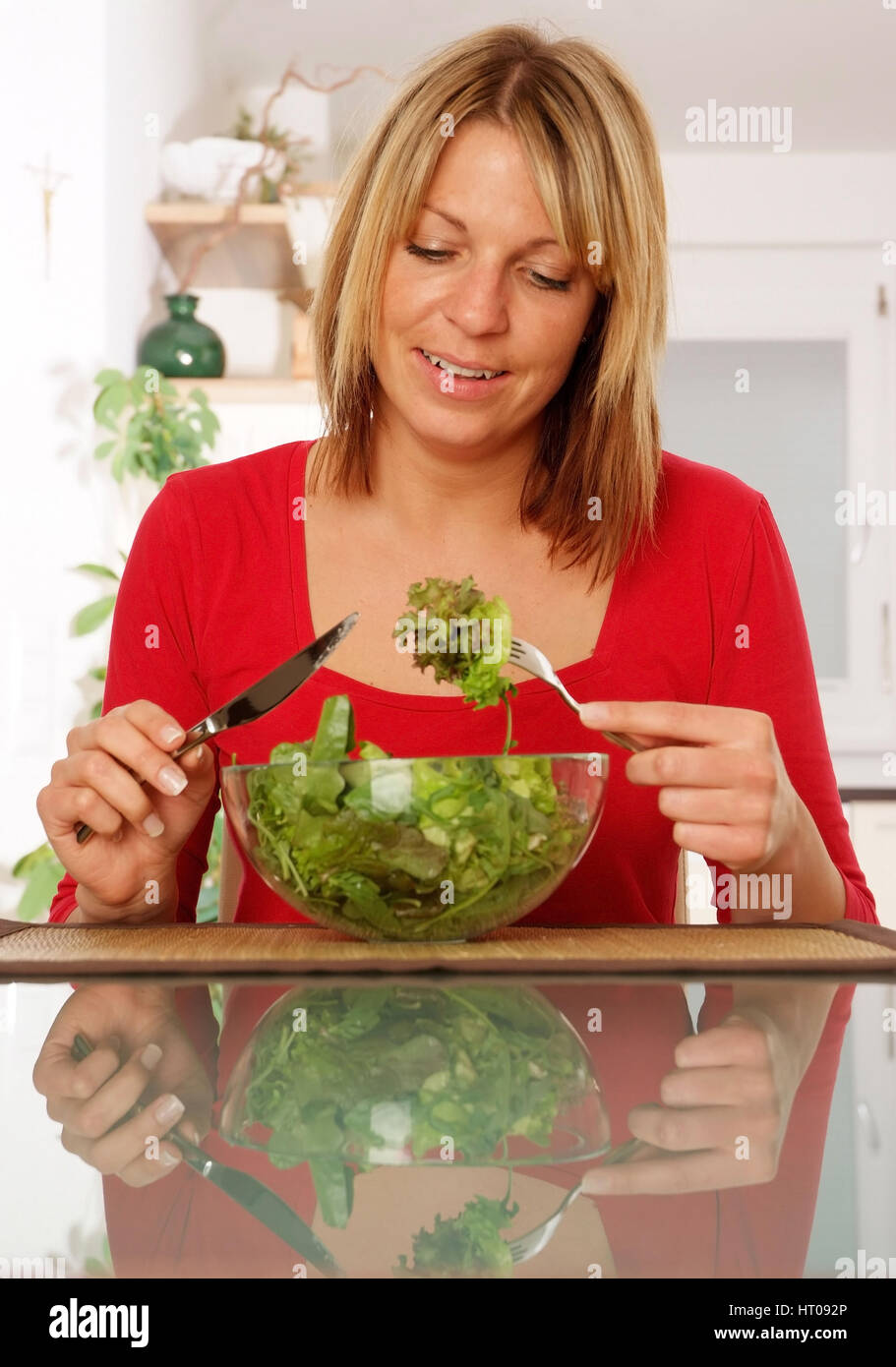 Junge Frau isst gruenen Salat aus der Schuessel - young woman eats ...