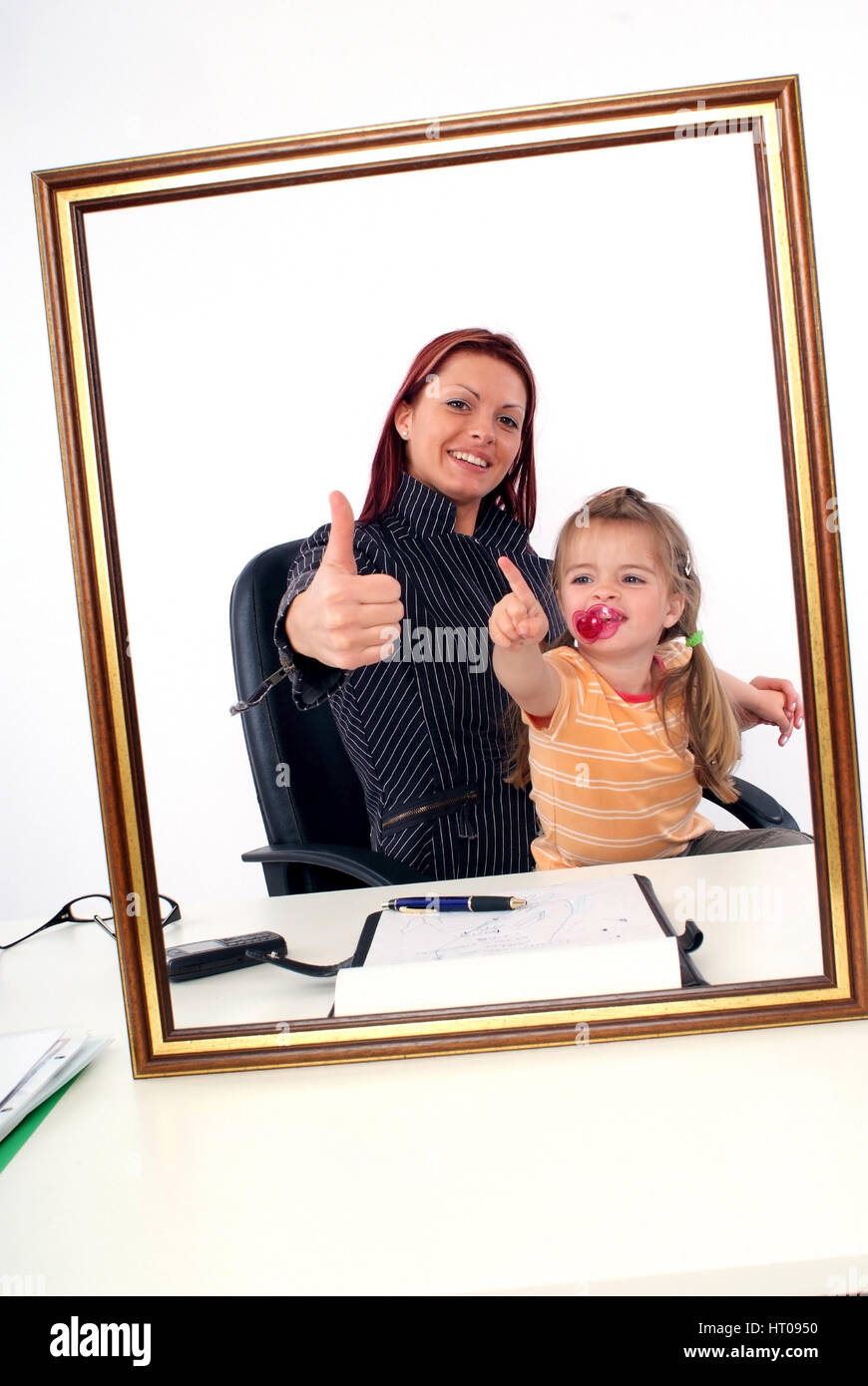 Symbolbild Karrierefrau und Mutter, erfolgreiche Geschaeftsfrau mit Tochter am Schreibtisch - sucessful businesswoman with daughter Stock Photo