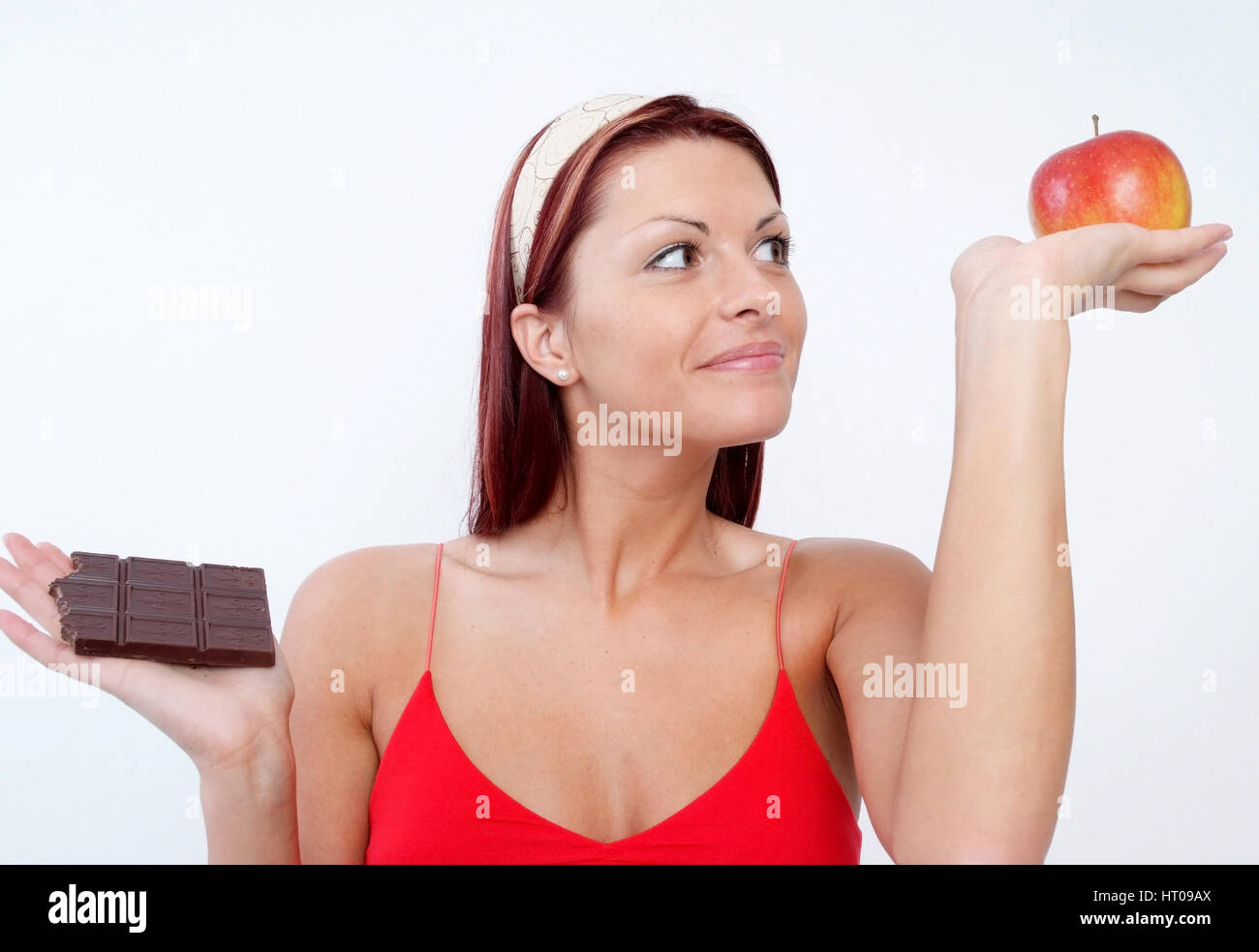Junge Frau mit Schokolade und Apfel, Suesses oder Vitamine - young woman with chocolate and apple Stock Photo