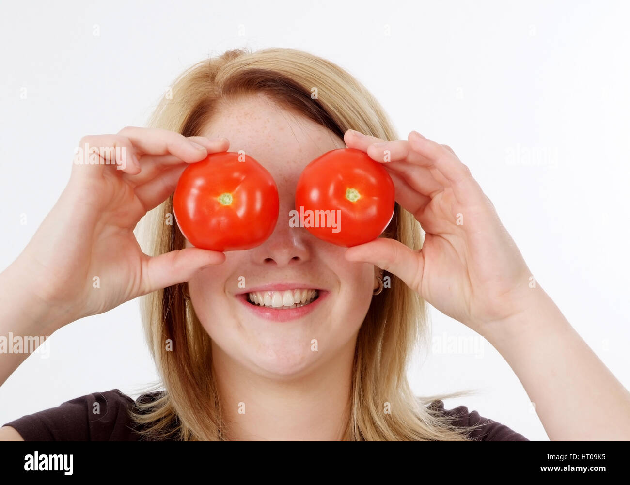 Junge Frau mit Tomaten auf den Augen - woman with tomatoes, to be blind for Stock Photo