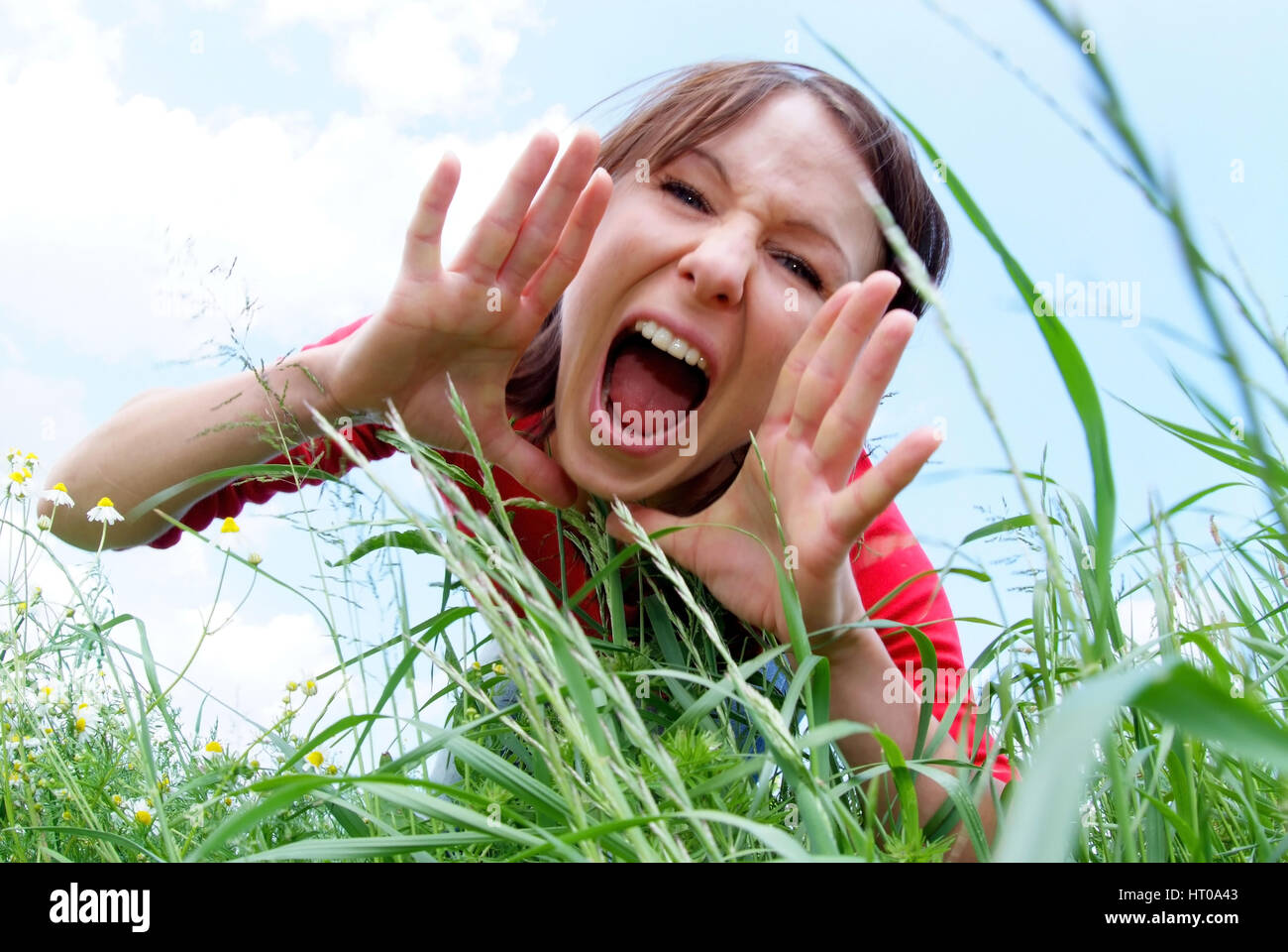 schreiende Frau im Gras - screaming woman in grass Stock Photo