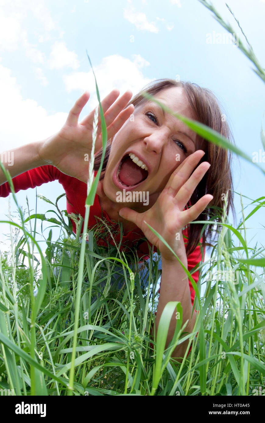 schreiende Frau im Gras - screaming woman in grass Stock Photo
