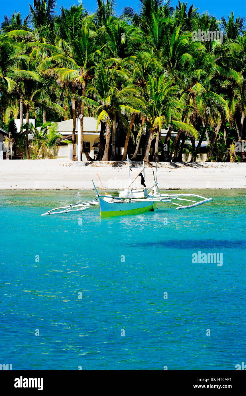 Simple fishing boat anchored on white sand beach Stock Photo - Alamy