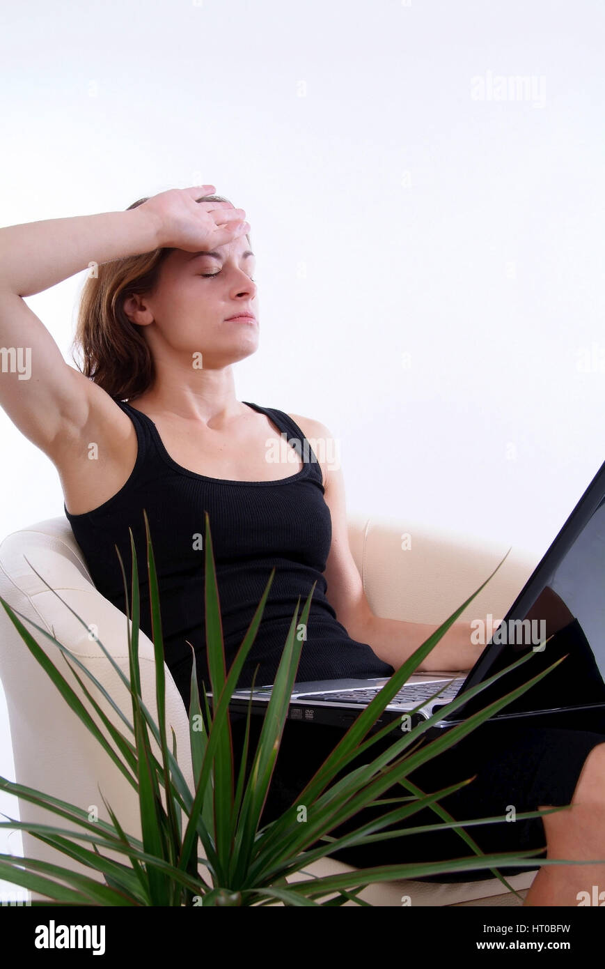 Junge, ueberarbeitete Frau mit Laptop am Scho? - young, stressed woman using laptop Stock Photo