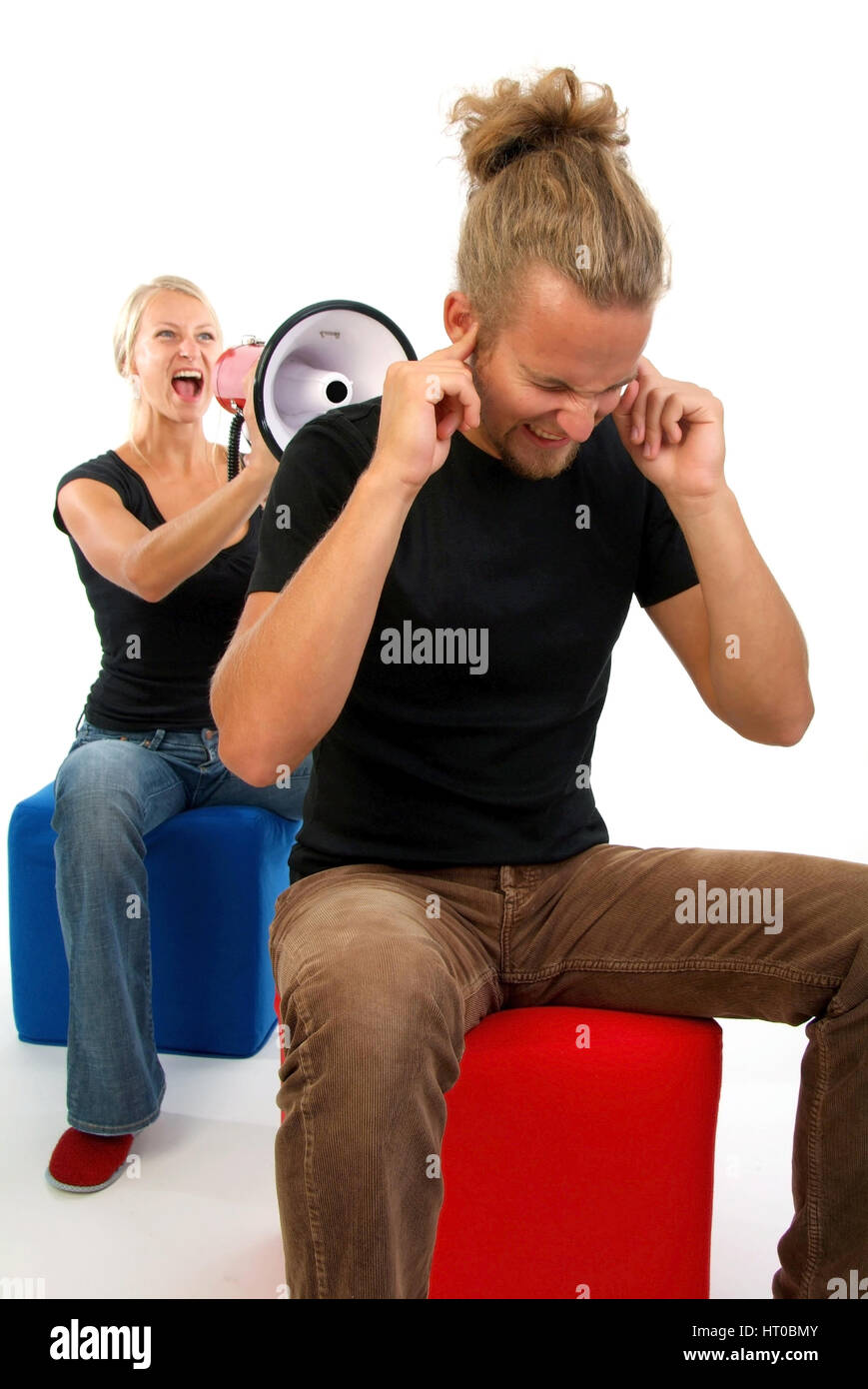 Symbolbild Beziehungskrise, Junge Frau schreit in Megaphon, Mann h?lt dsich die Ohren zu - symbolic for marital quarrel Stock Photo