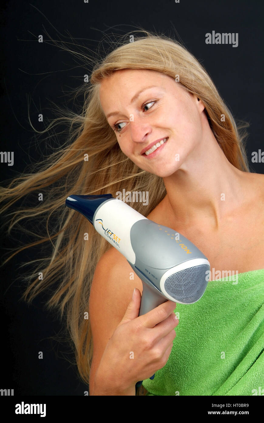 Junge, blonde Frau f?nt sich die Haare - woman with hair dryer Stock Photo