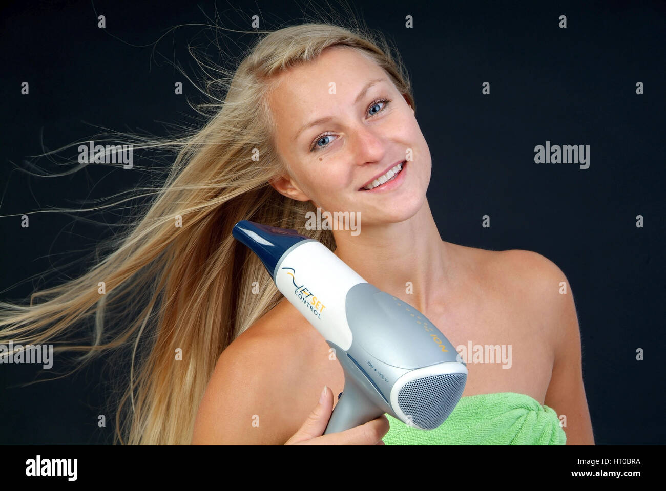 Junge, blonde Frau f?nt sich die Haare - woman with hair dryer Stock Photo