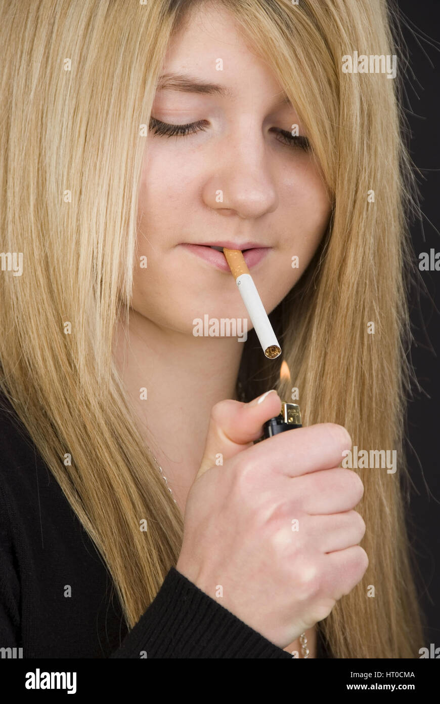 Jugendliches M‰dchen z¸ndet sich eine  Zigarette an - Teenager smokes a cigaret Stock Photo