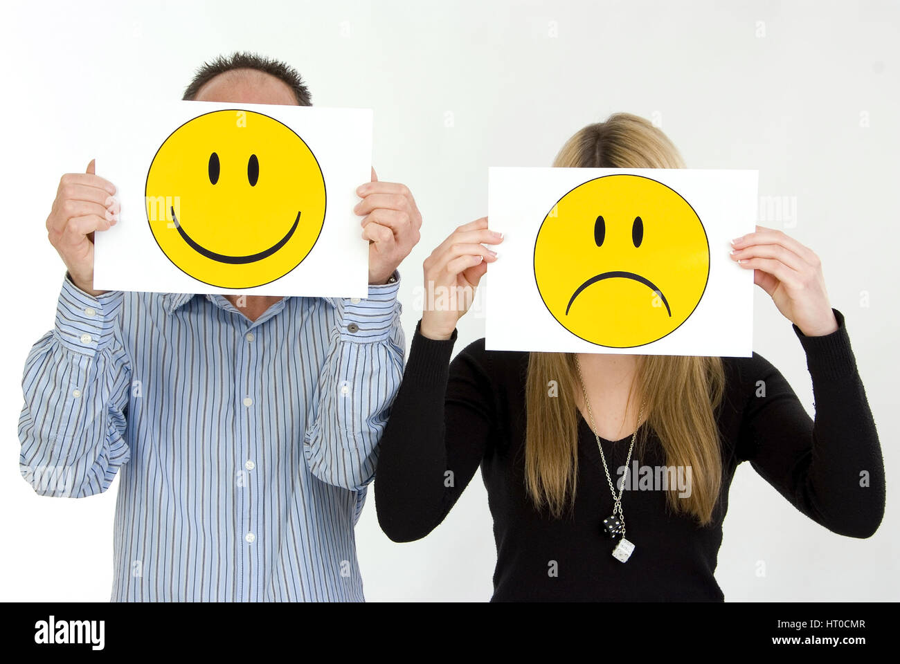lachender Mann, traurige Frau, Symbolbild unausgeglichene Partnerschaft - sad woman, lucky man Stock Photo