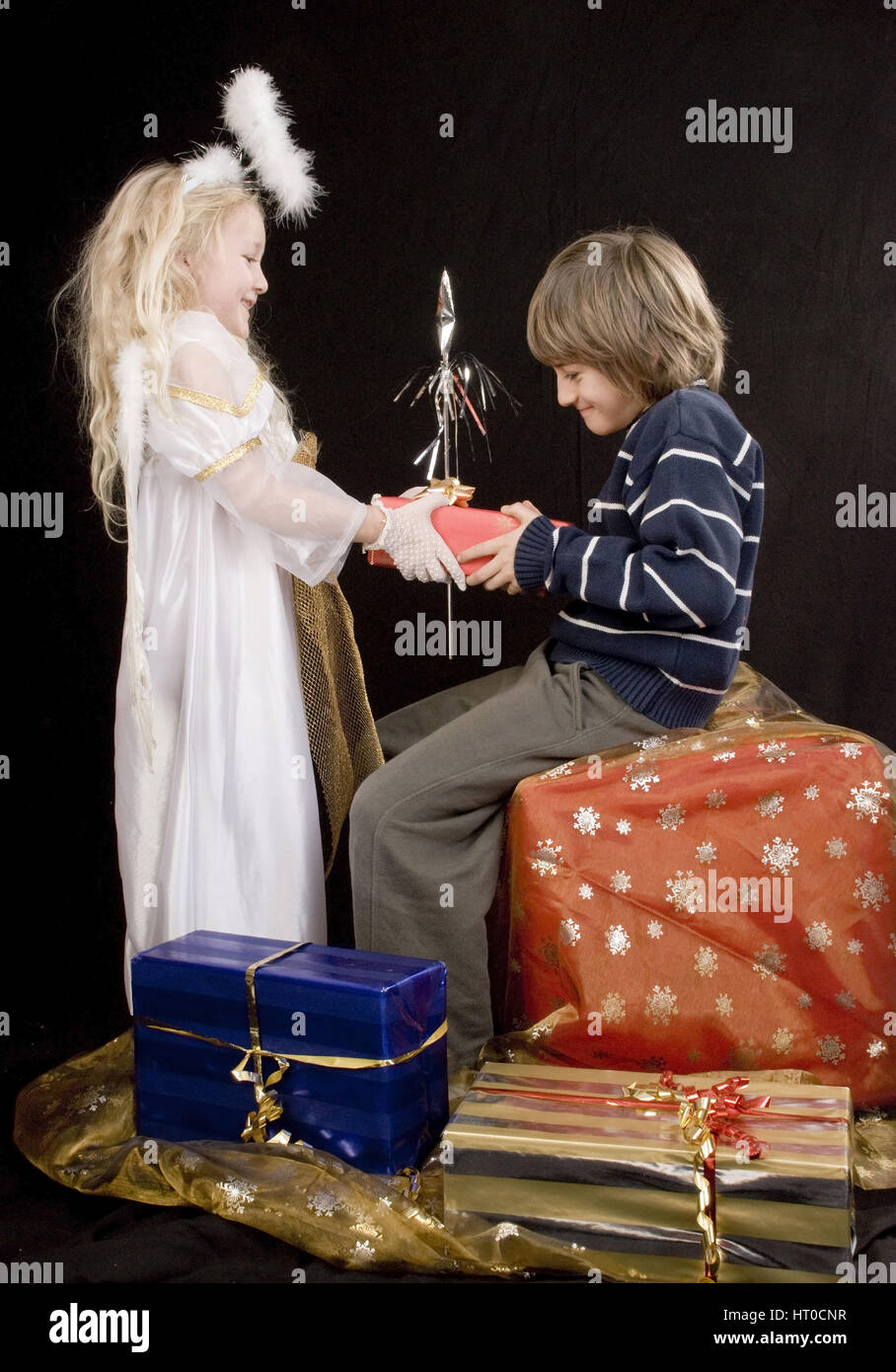 Christkind bringt Jungem ein Weihnachtsgerschenk - present from Christ Child Stock Photo