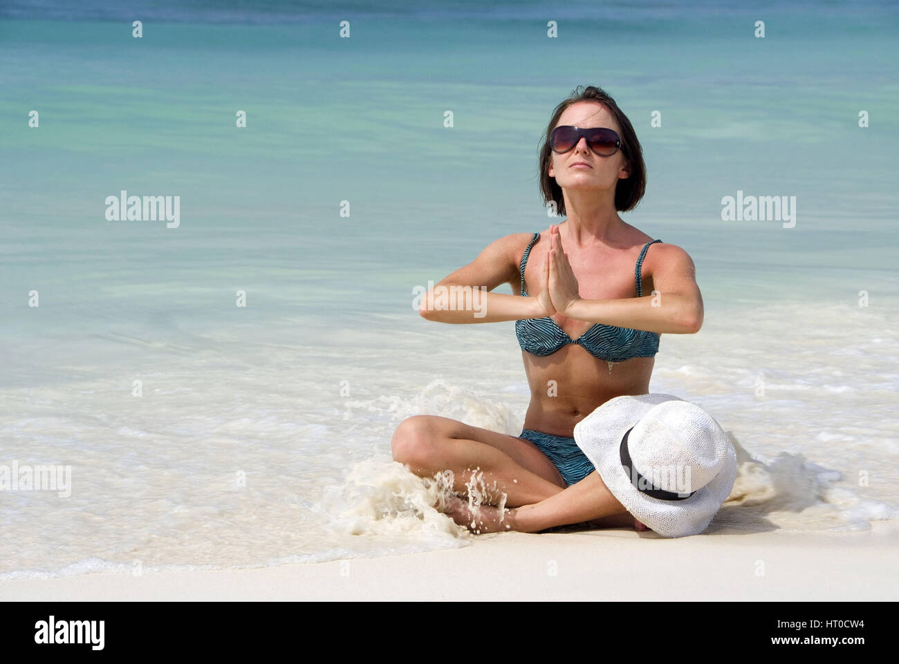 Frau macht Joga am Sandstrand - woman does yoga on the beach Stock Photo