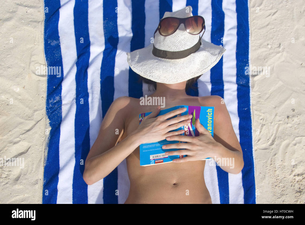 Frau entspannt mit Buch am Strand - woman with book relaxing on the beach Stock Photo