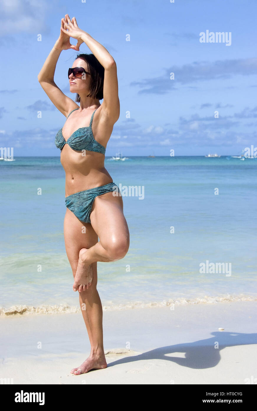 Frau macht Joga am Sandstrand - woman does yoga on the beach Stock Photo