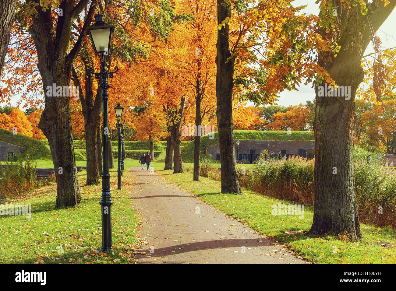 People walking by the old autumn park Stock Photo - Alamy