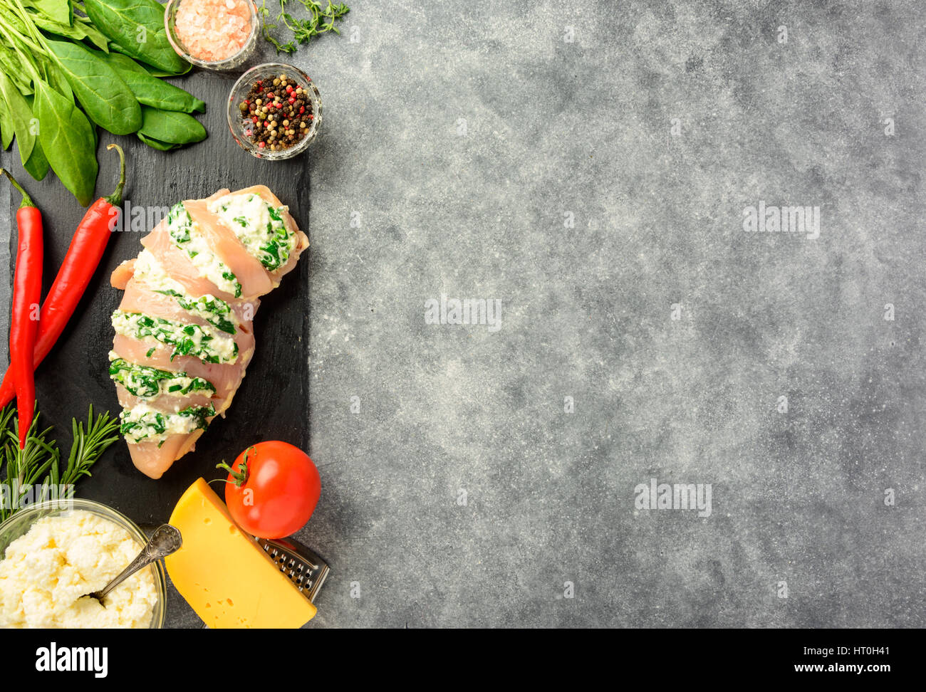 Prepared for cooking chicken fillet with spinach and cheese on a dark background. Top view , copy space. Stock Photo