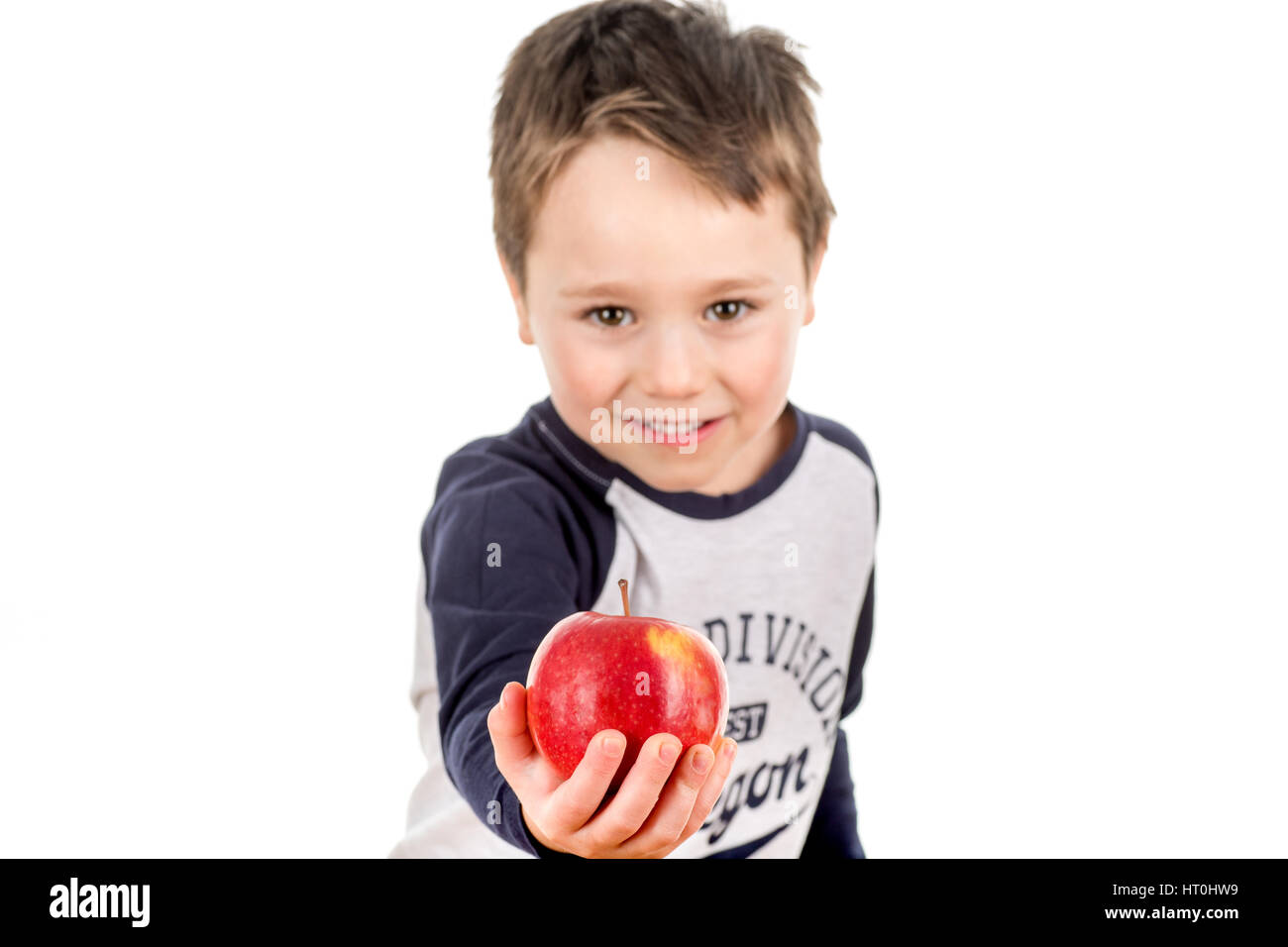 Little smiley boy holding an apple in his hand. Isolated on a white background. Stock Photo