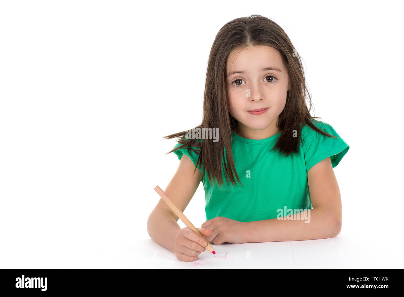 School girl drawing a picture with a crayon. Isolated on a white background. Stock Photo