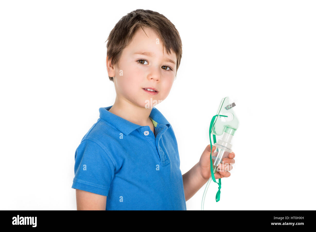 5 years old boy with asthma holding facemask from nebulizer inhaler machine. Isolated on a white background. Stock Photo
