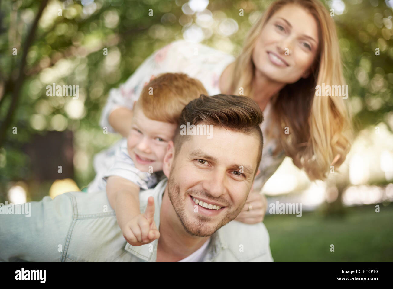 Portrait of happy family at the park Stock Photo - Alamy