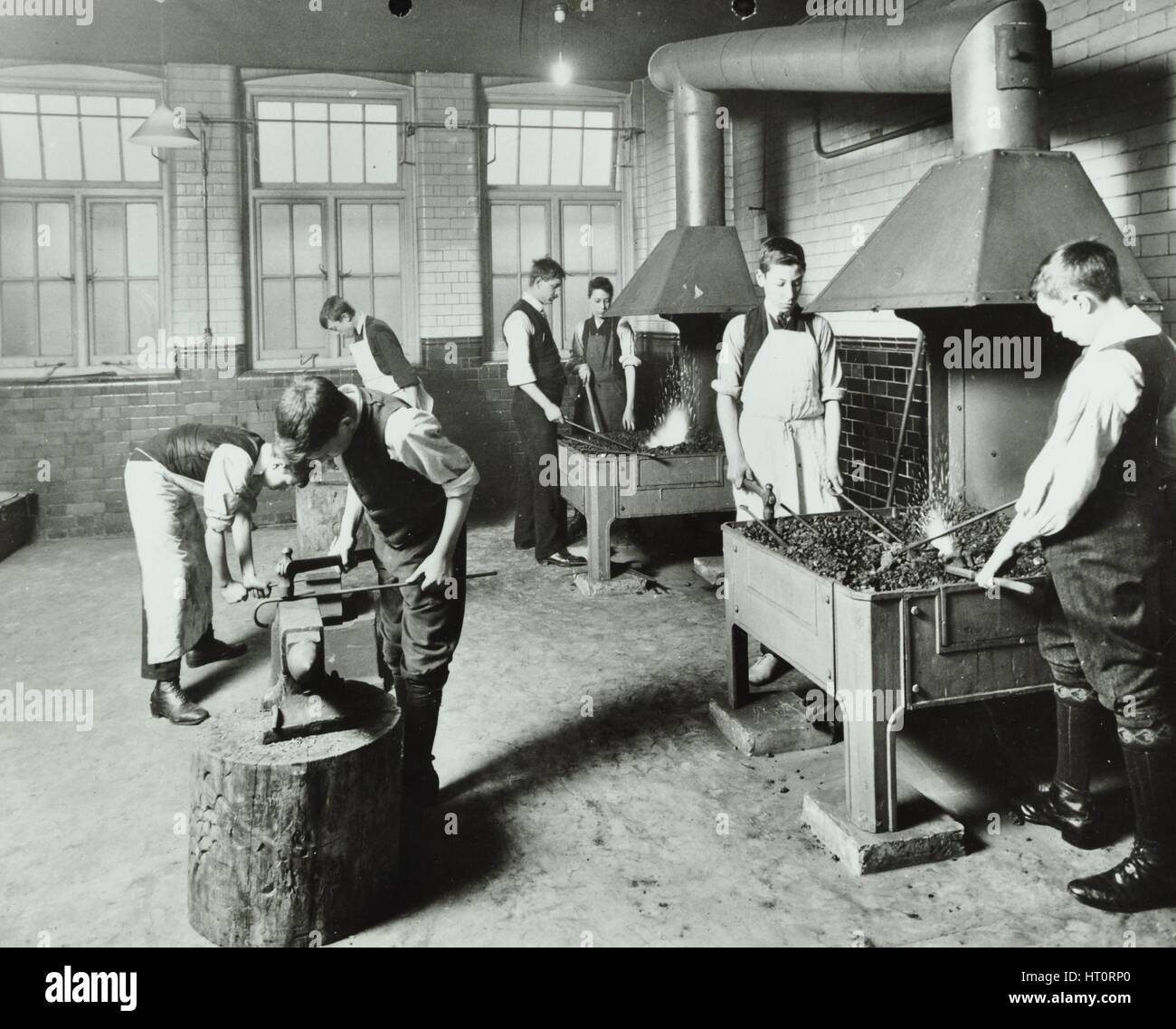 Boys using forges in a blacksmith's shop, Beaufoy Institute, London, 1911. Artist: Unknown. Stock Photo
