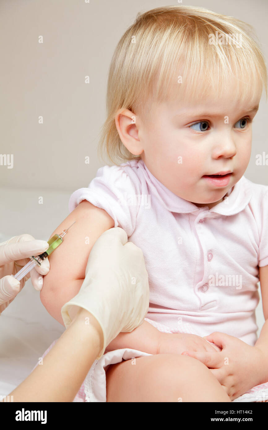 Doctor giving child intramuscular injection hires stock photography