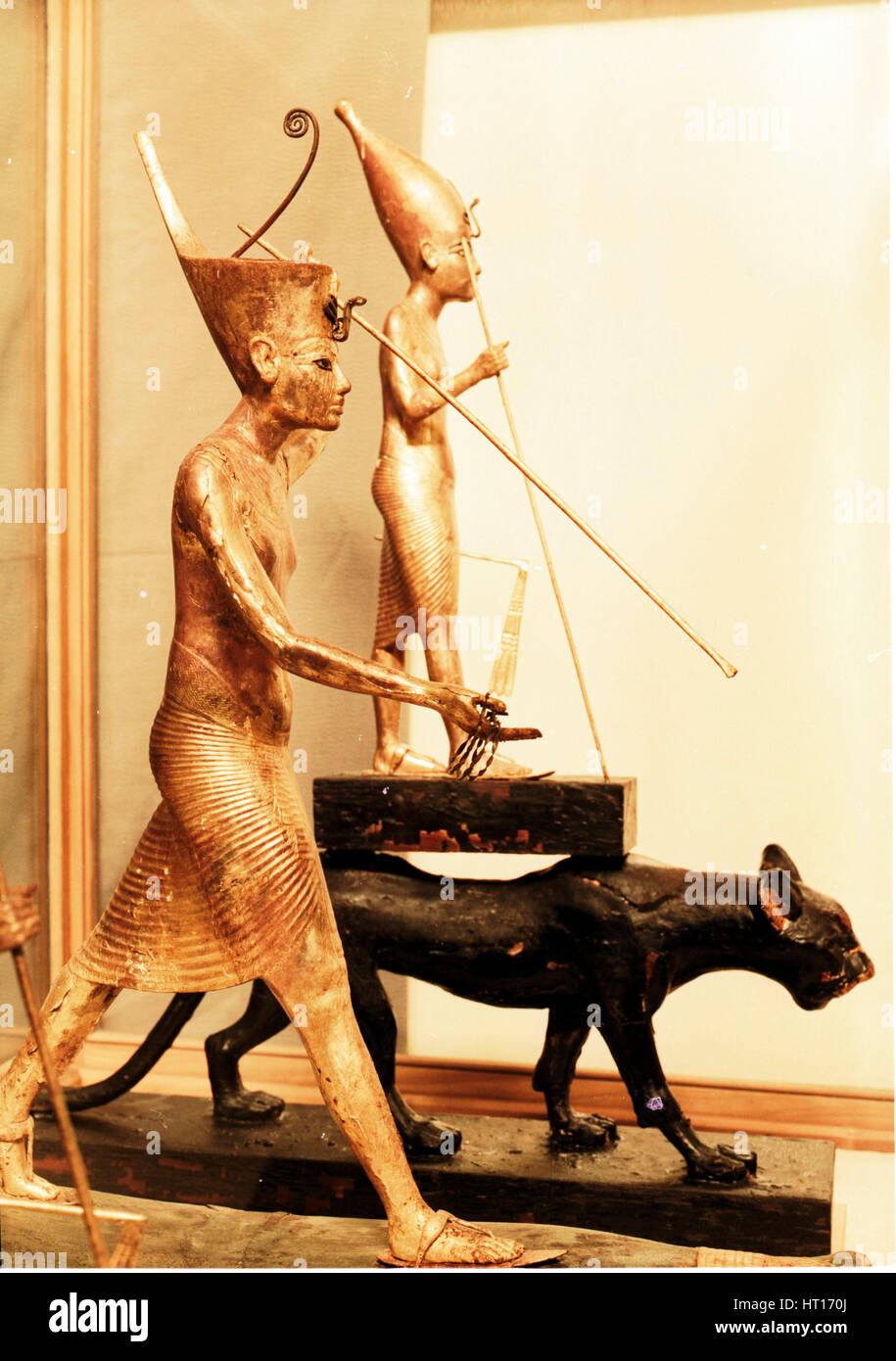 Front figure: Gilded statue of Tutankhamun on a light papyrus boatwearing the red crown of Lower Egy Artist: Werner Forman. Stock Photo