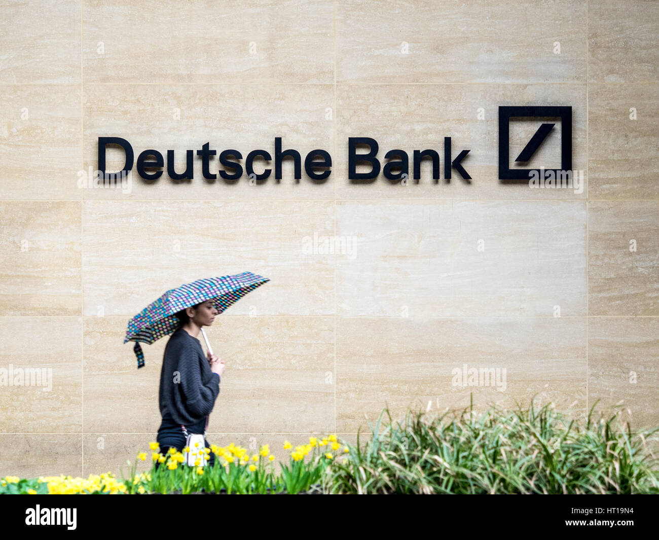 Deutsche Bank London - a woman walk past the London offices of Deutsche Bank in the Square Mile, London's Financial District. Stock Photo