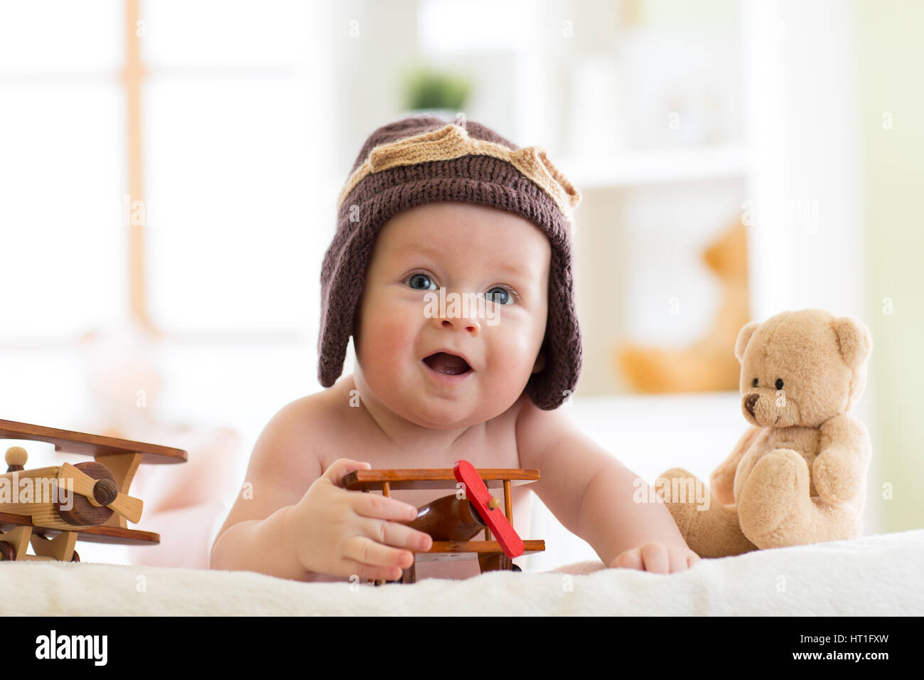 Little baby boy weared pilot hat with airplane and teddy bear toys Stock Photo