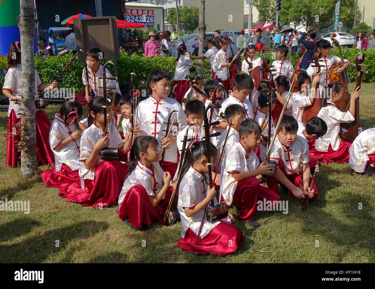 LUJHU, TAIWAN -- DECEMBER 12, 2015: A children's orchestra for traditional Chinese music waits for their performance at the 2015 Lujhu Tomato Festival Stock Photo