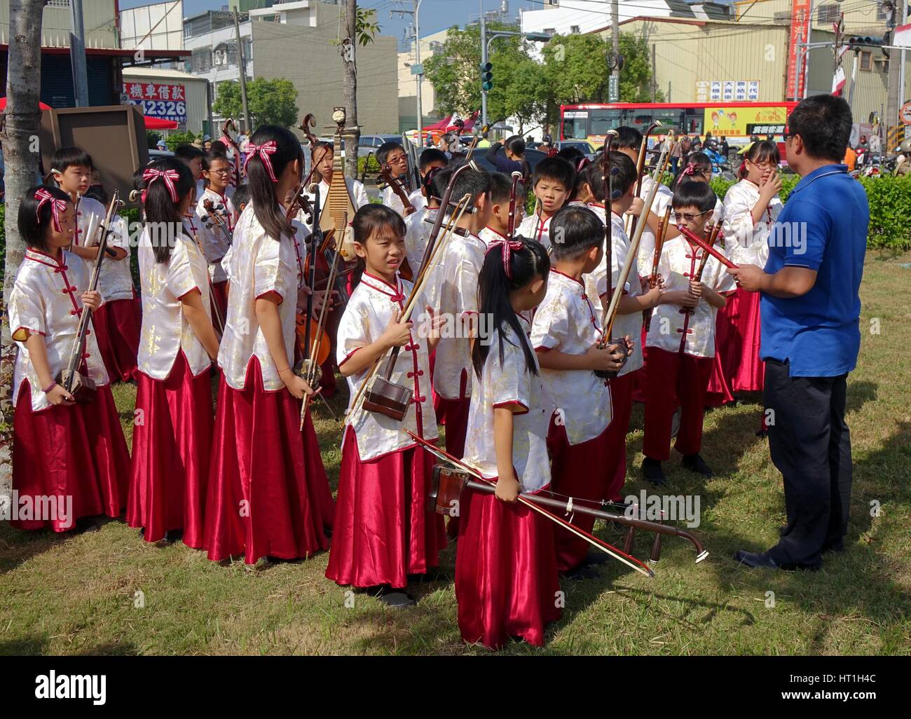 LUJHU, TAIWAN -- DECEMBER 12, 2015: A children's orchestra for traditional Chinese music waits for their performance at the 2015 Lujhu Tomato Festival Stock Photo