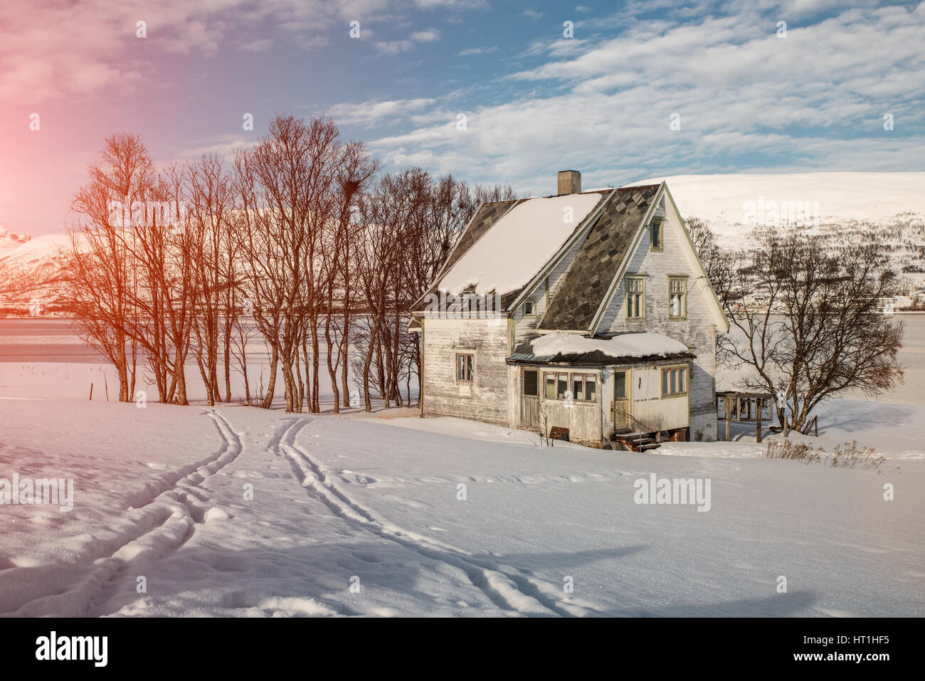 White old house by te frozen lake near the mountains in Norway. Stock Photo