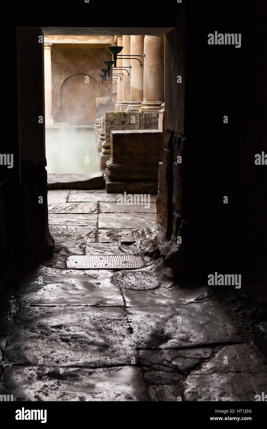 Steaming waters of the Great Bath viewed through the doorway of the heated room at the Roman Bath complex in Bath, UK. Stock Photo