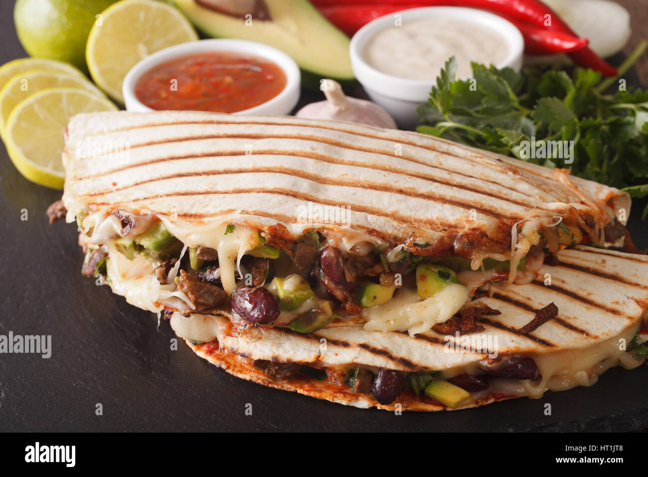 Mexican food: Quesadillas with beef, beans, avocado and cheese close-up on the table. horizontal Stock Photo