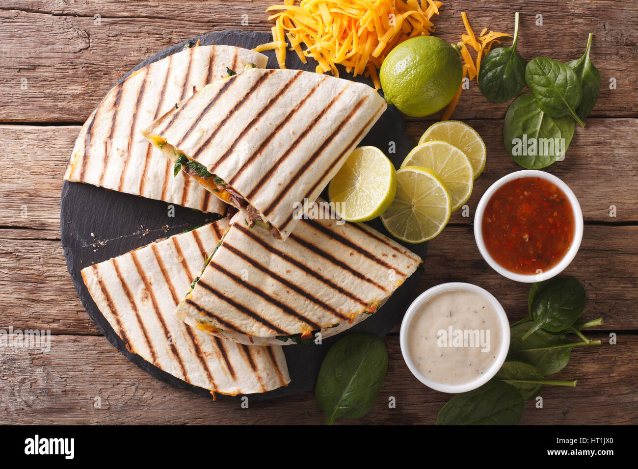 quesadilla with meat, spinach and cheddar cheese close-up on the table. horizontal view from above Stock Photo