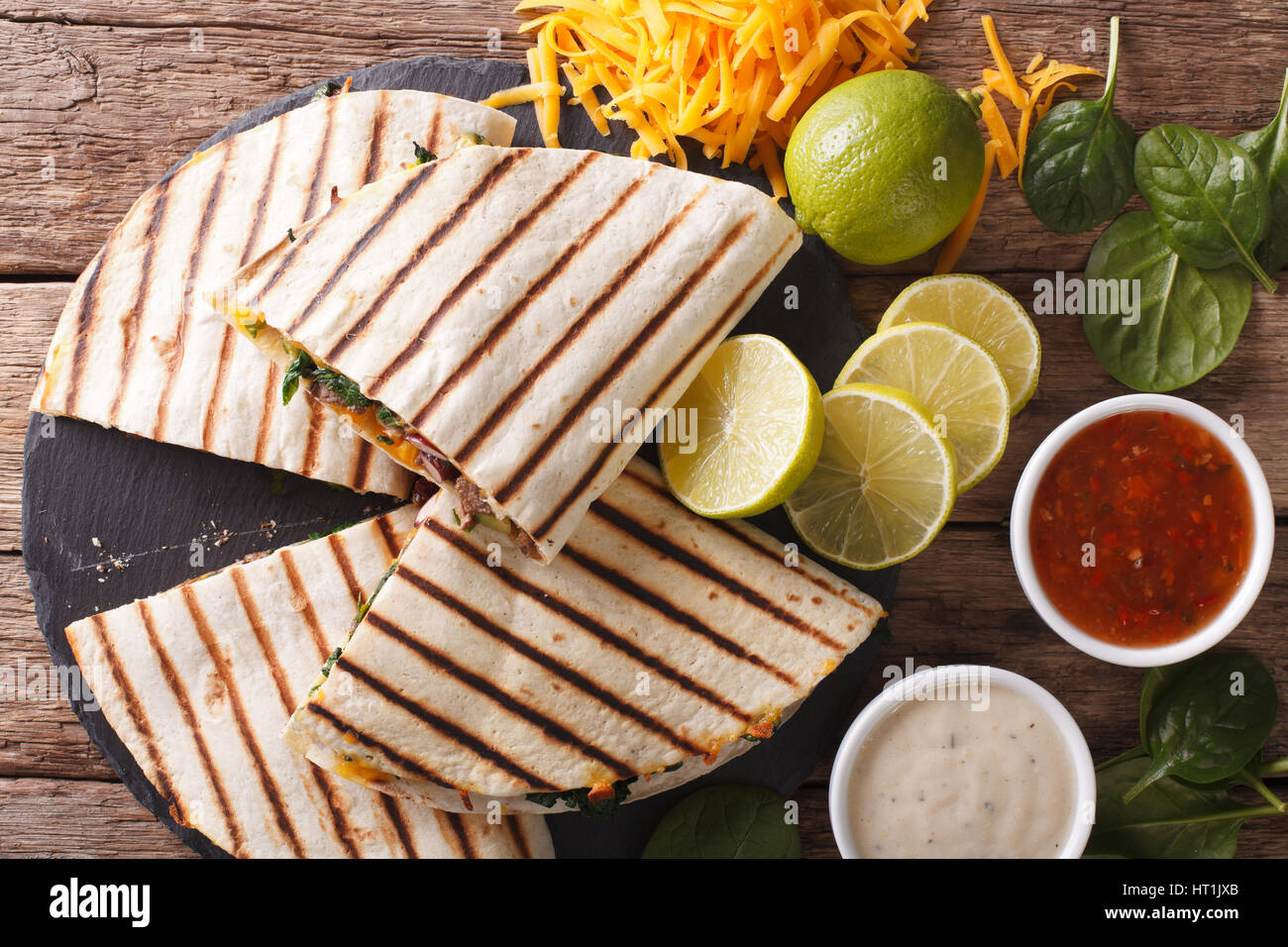 Grilled quesadilla with beef, spinach and cheddar cheese close-up on the table. horizontal view from above Stock Photo