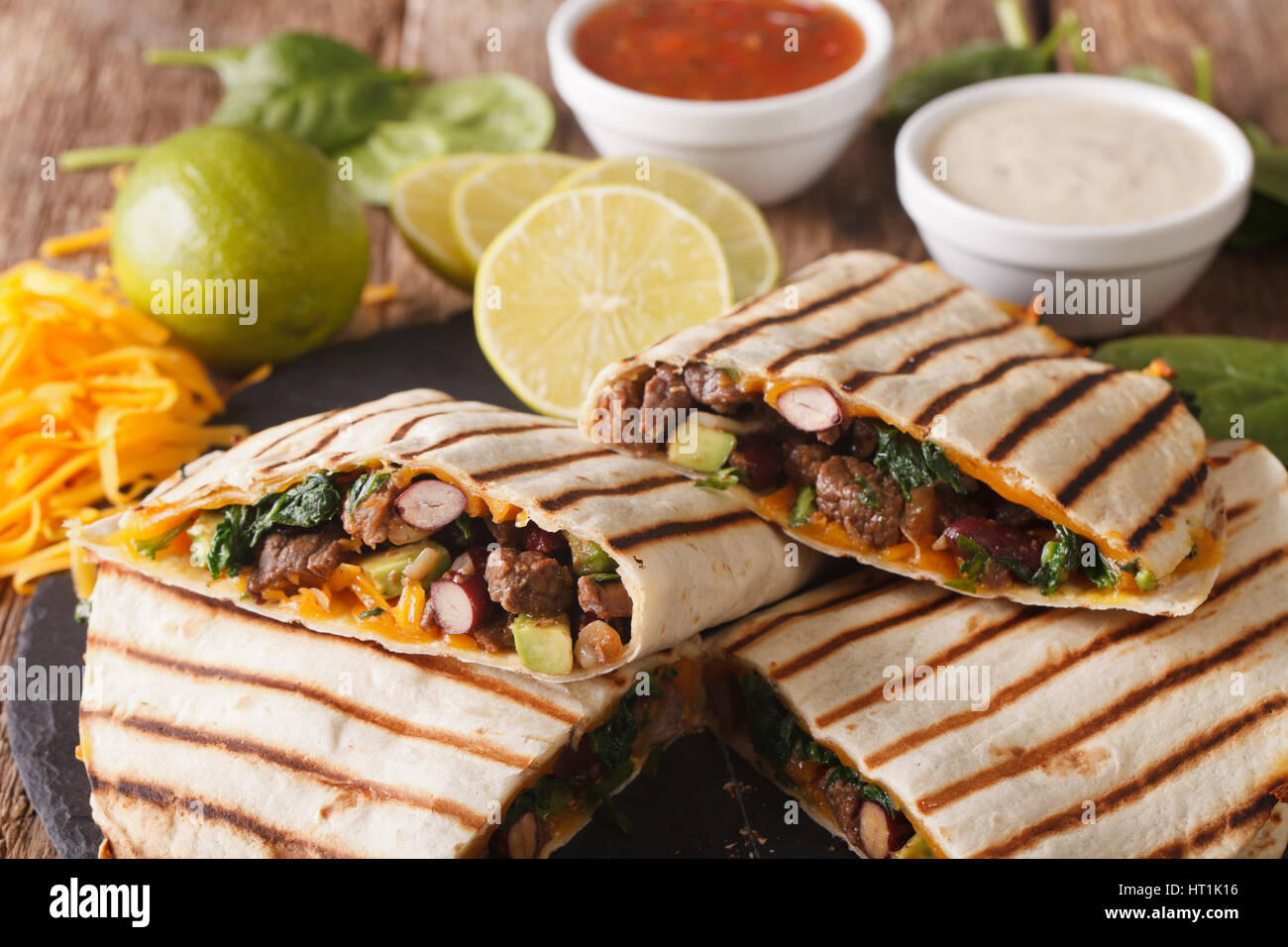 Grilled quesadilla with beef, spinach and cheddar cheese close-up on the table. Horizontal Stock Photo