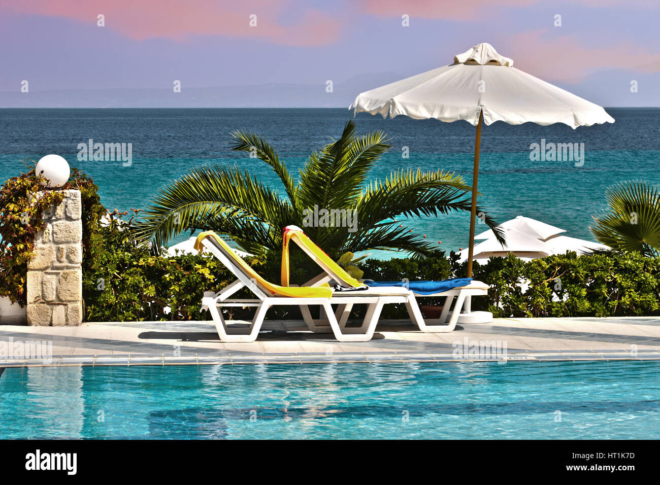 Plastic chair beside the pool with a perspective close to the sea