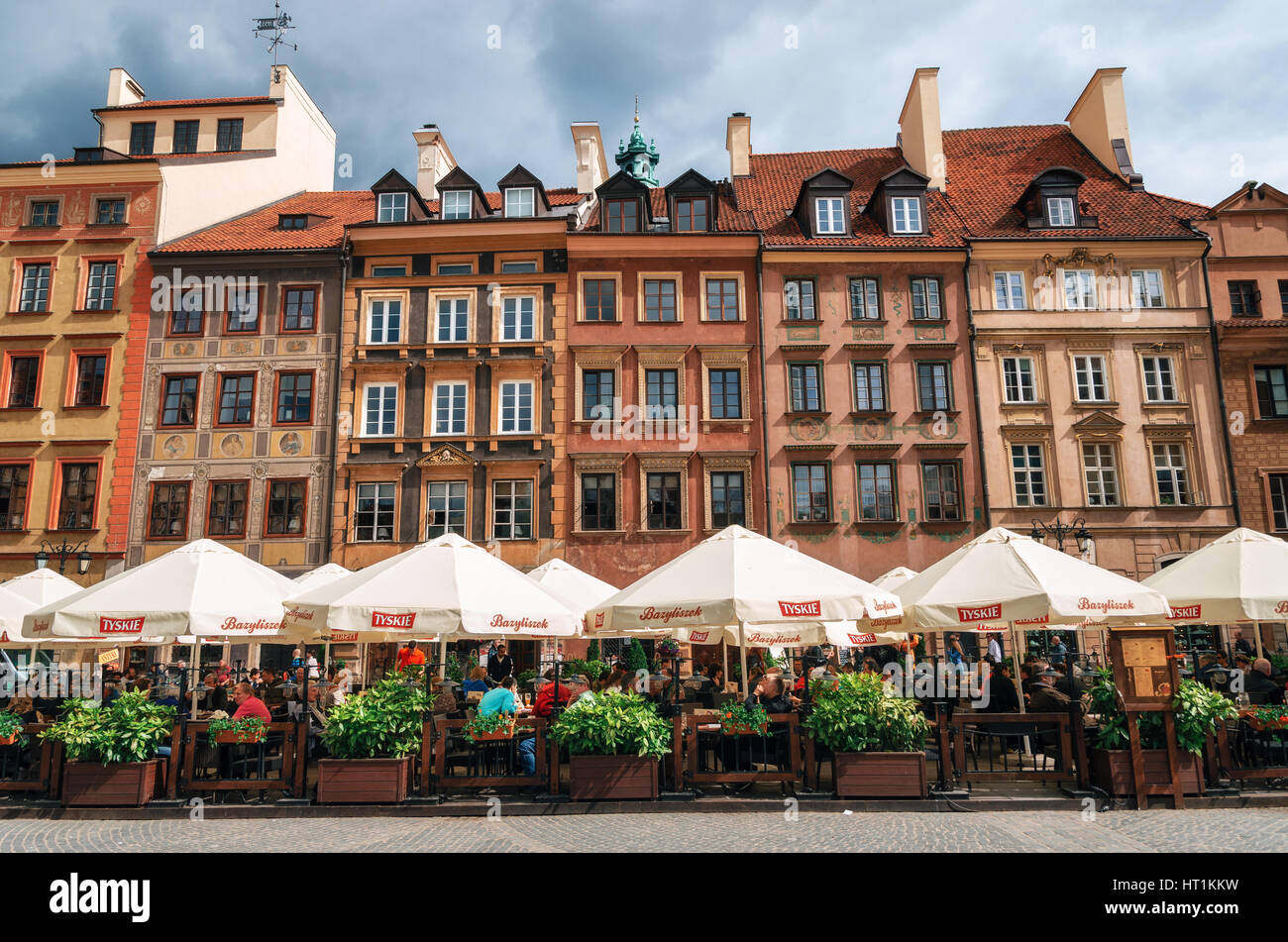 Warsaw, Poland - May 28, 2015: Traditional cafe with tourists against typical old houses on Old town Market square in Warsaw in a summer Stock Photo