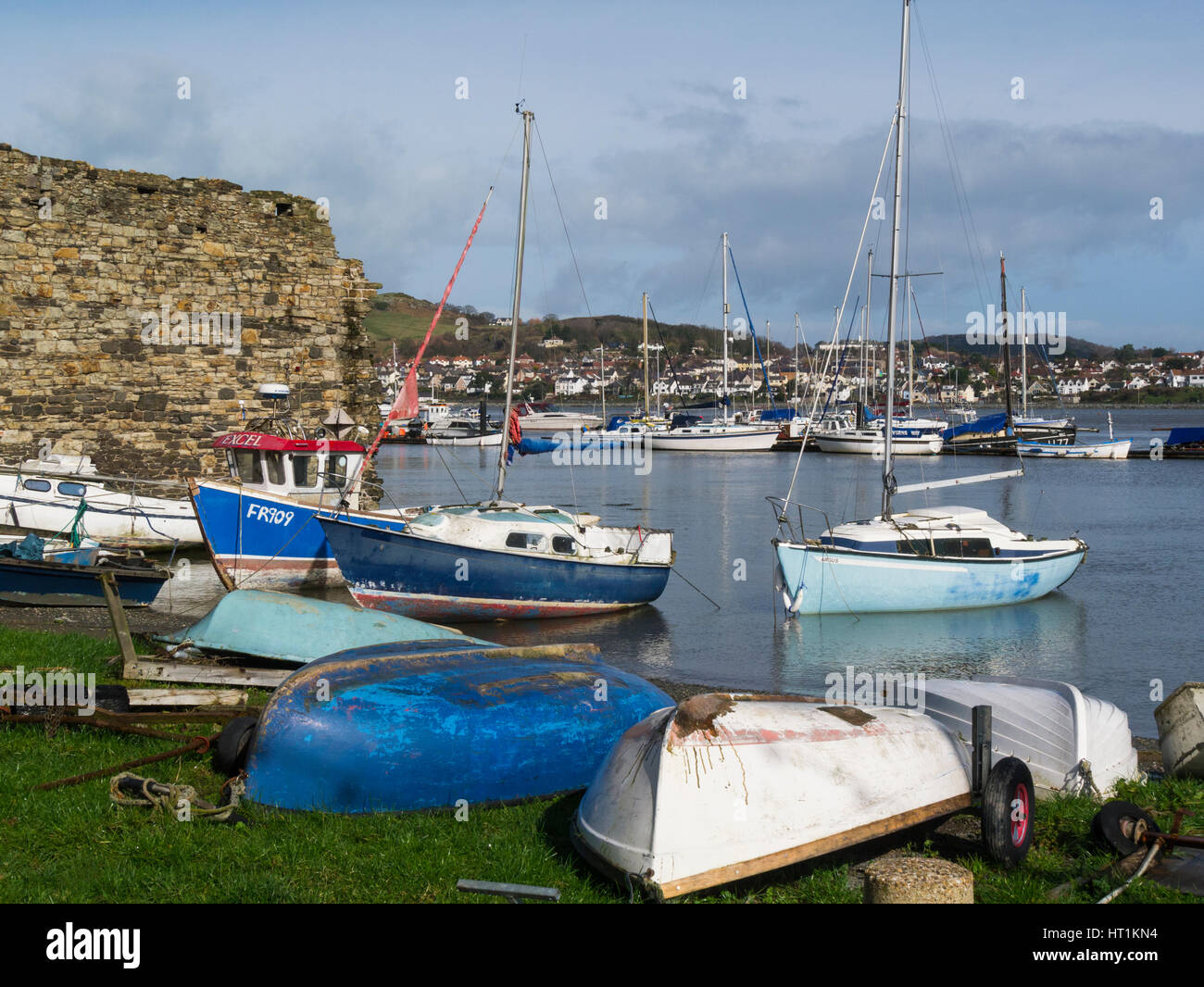 View from Conwy quayside to Deganwy on opposite bank across moored yachts and upturned rowing boats North Wales UK Stock Photo