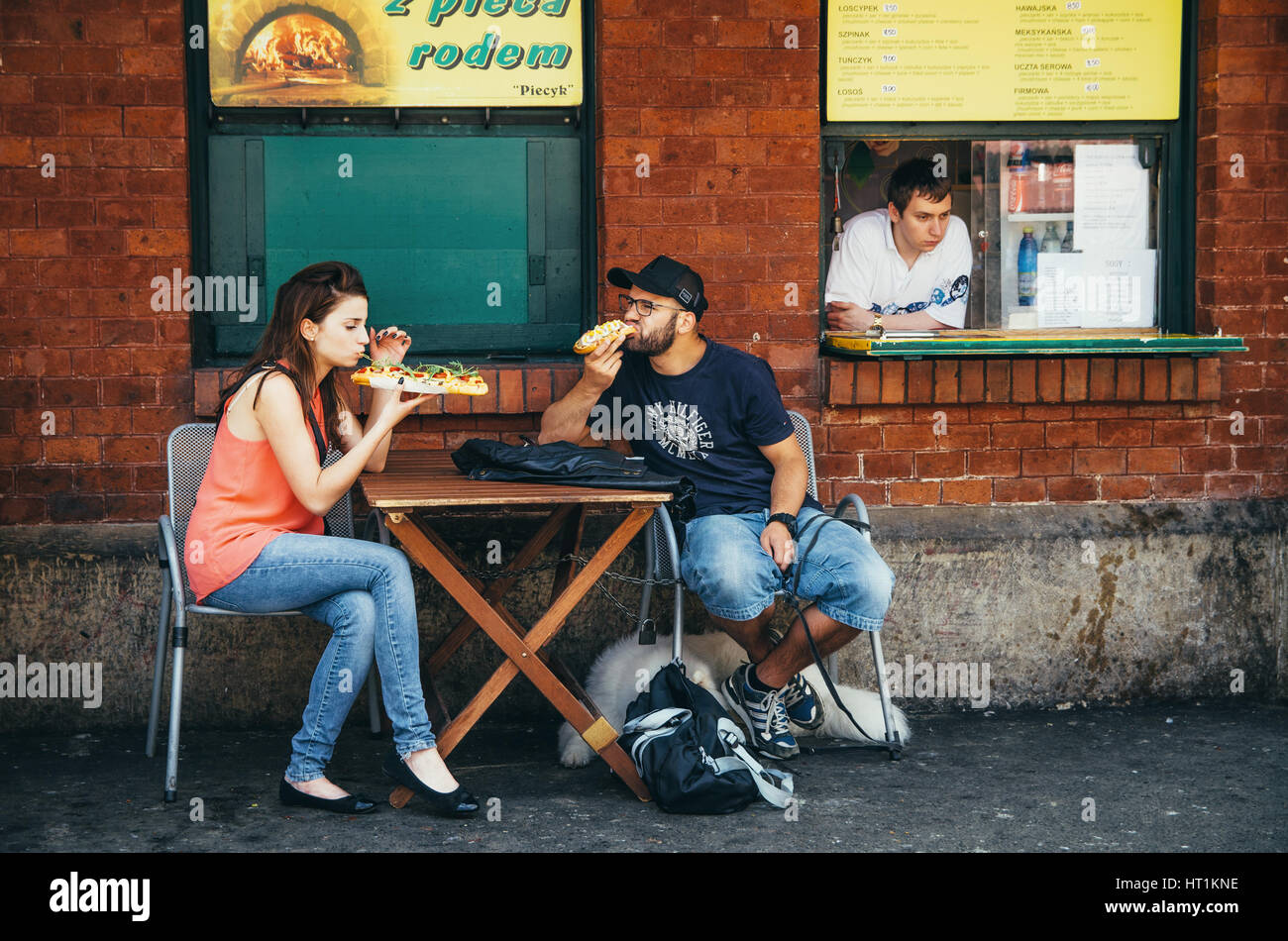 KRAKOW, POLAND - JUNE 26, 2015: The couple eat traditional polish fastfood zapekanka in Nowy Square Stock Photo