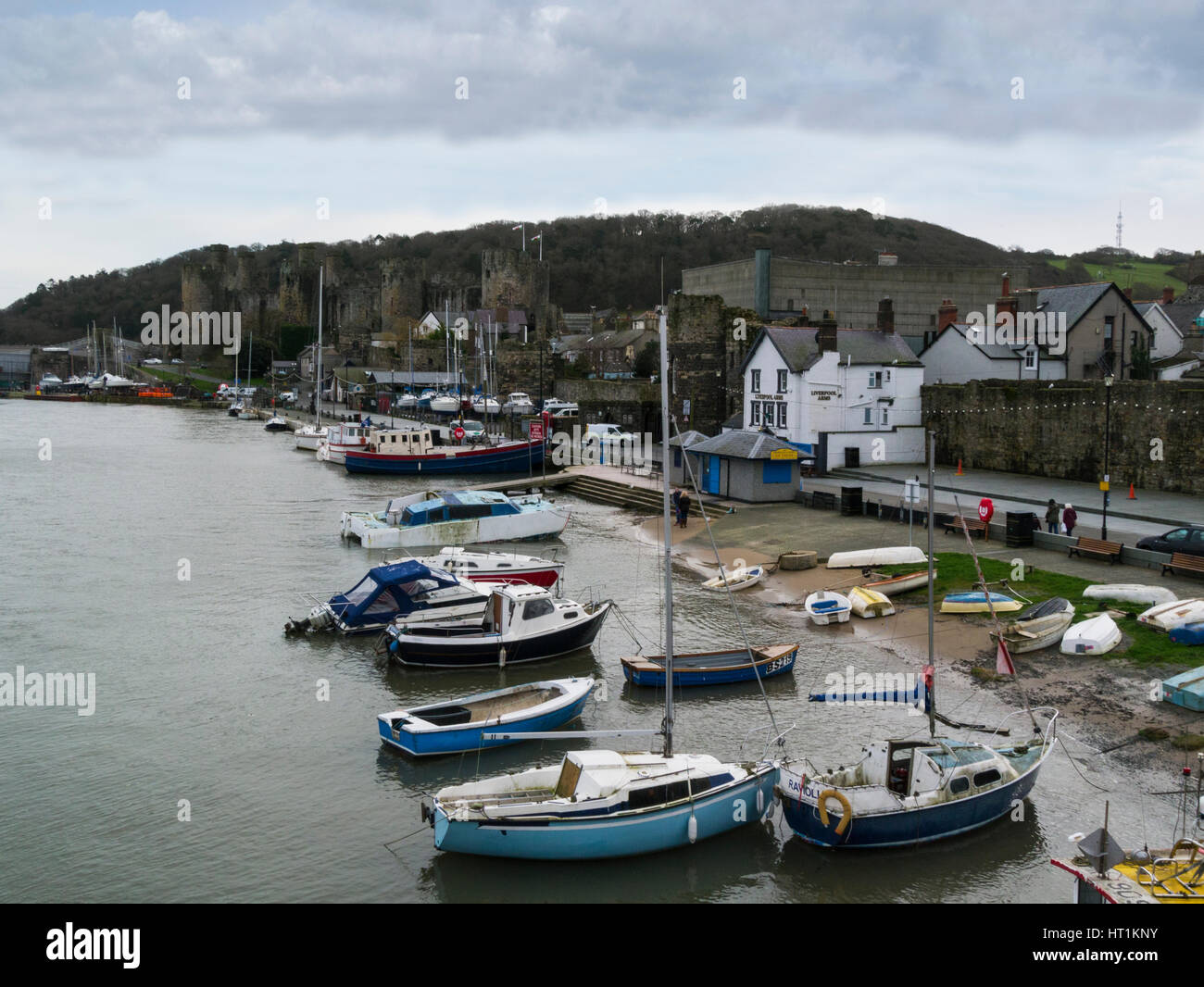 View across to Edward 1s impressive 13thc castle along quayside  from the preserved town walls of medieval Conwy  North Wales Stock Photo