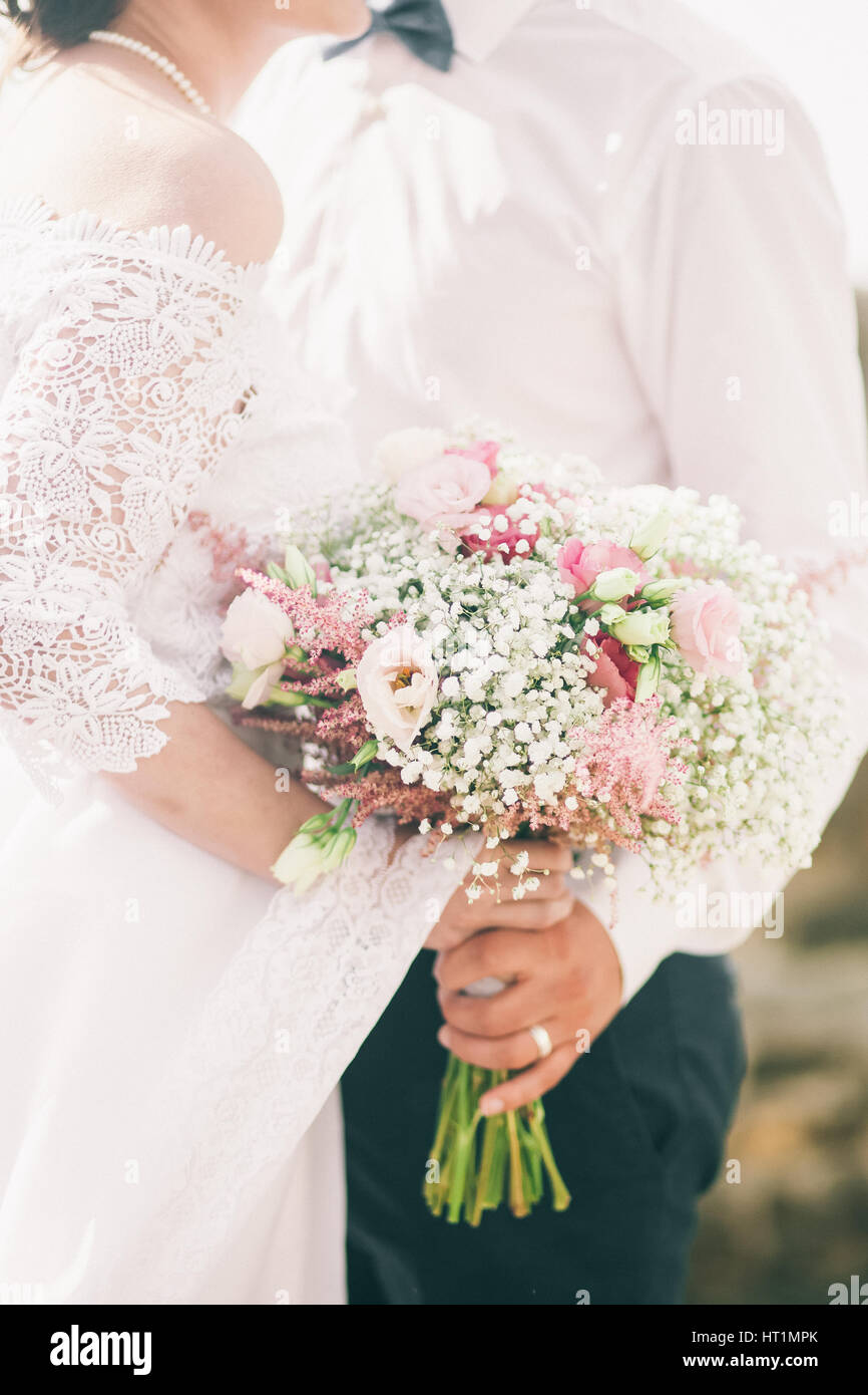 bride hold wedding bouquet of rose peonies and roses. Hands close up ...