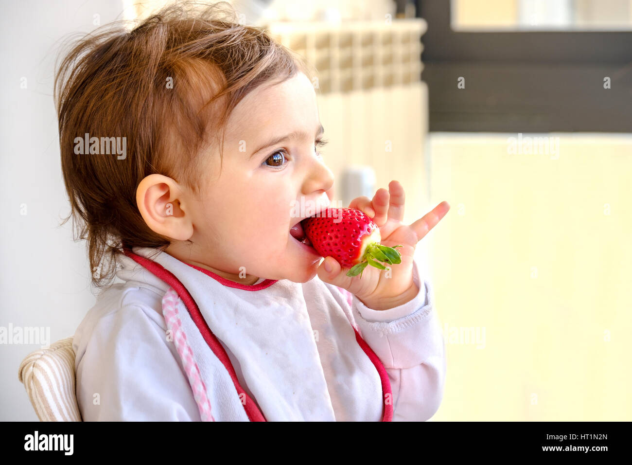 baby eat strawberry newborn eat fruit Stock Photo