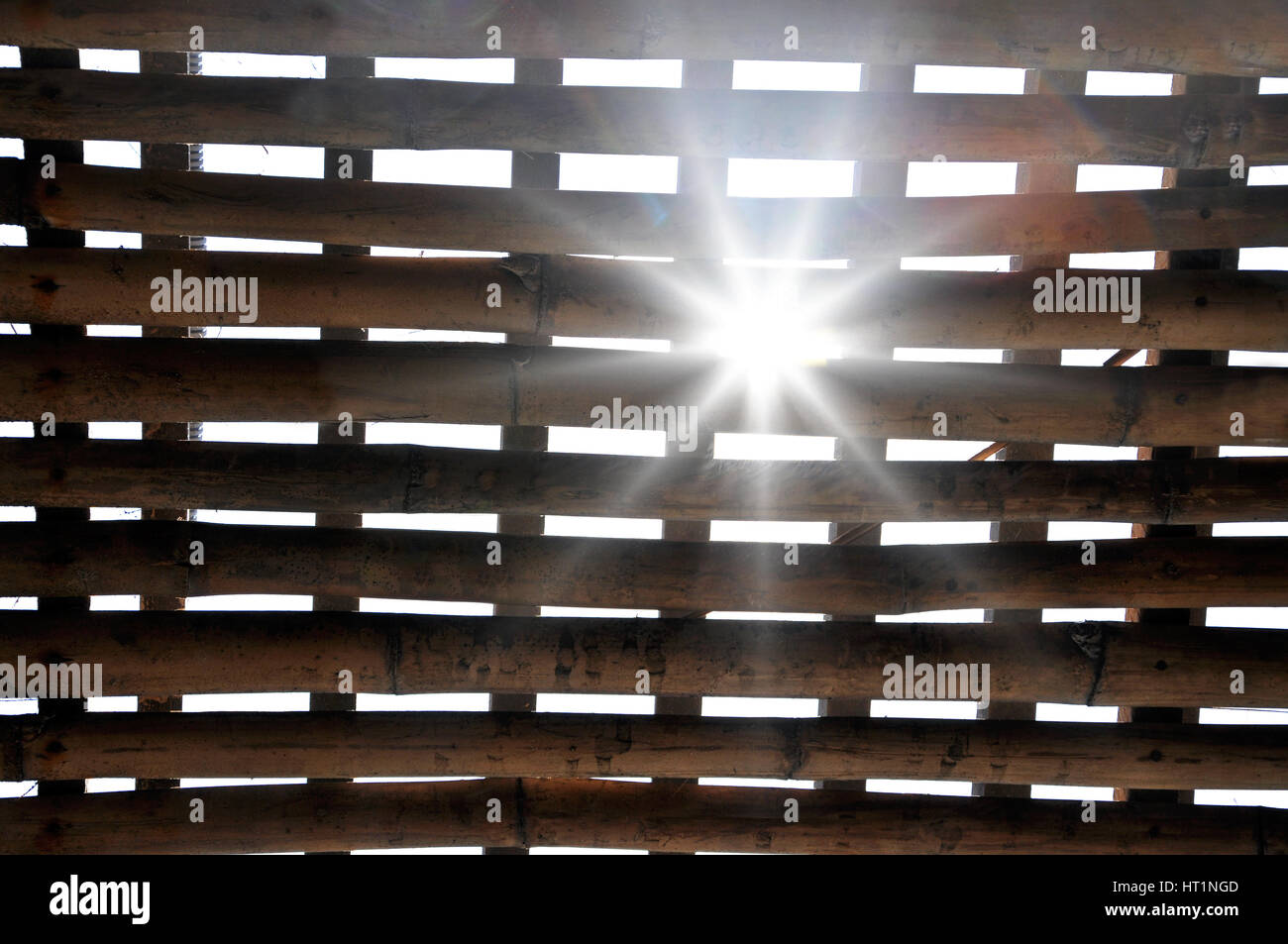 Sunrays coming through barred bamboo cage, jail in Vietnam Stock Photo
