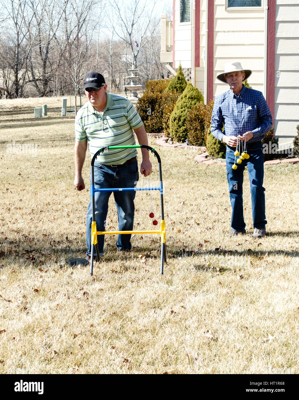 Two senior Caucasian men play ladder golf, or Ladder Toss game in the yard. USA. Stock Photo