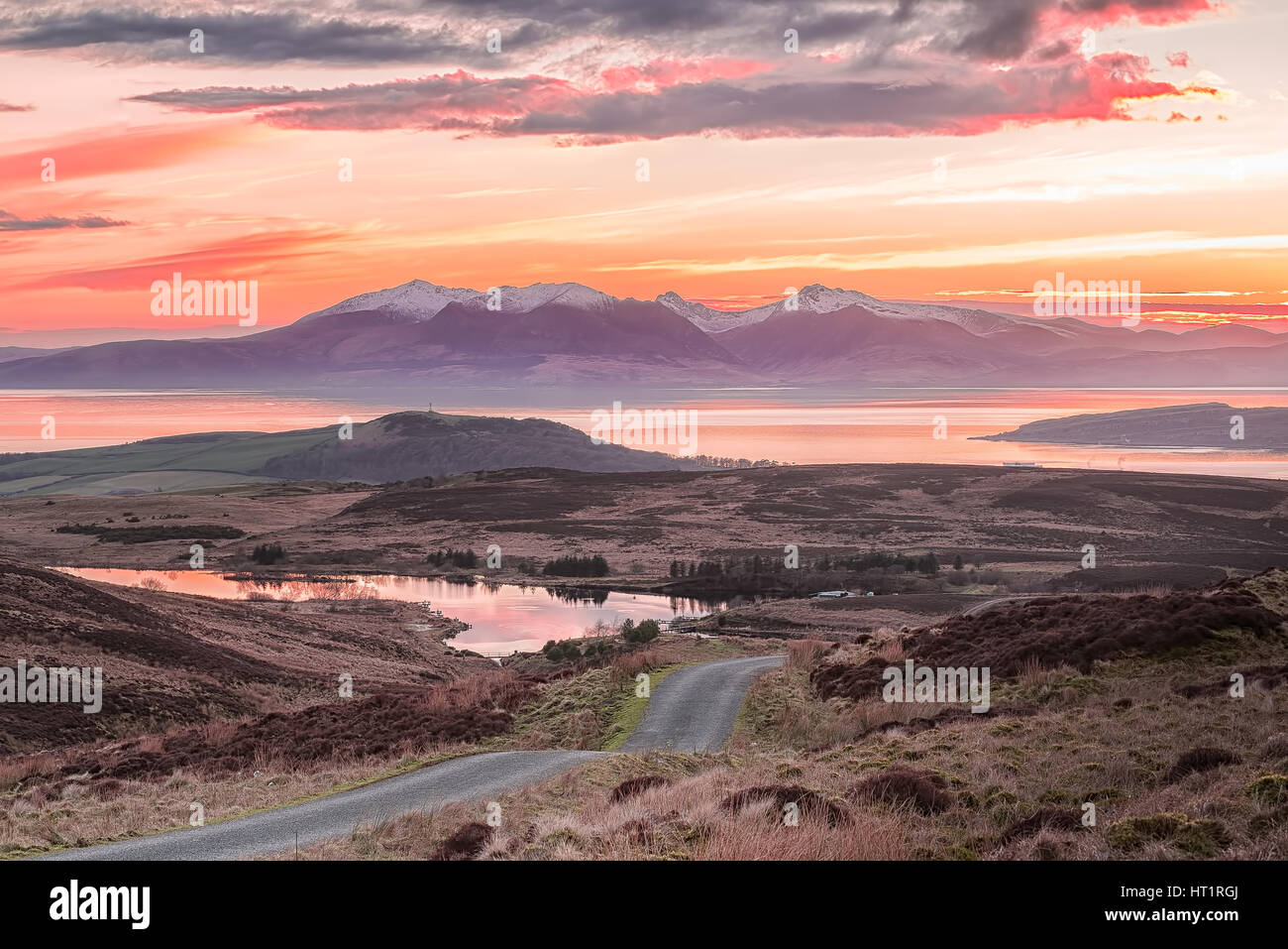 A view of Fairlie Moor Road down onto the Reservoir and Over to Arran. The Sun had just gone behind the Arran Hills and it was a Bitterly cold Day. Stock Photo