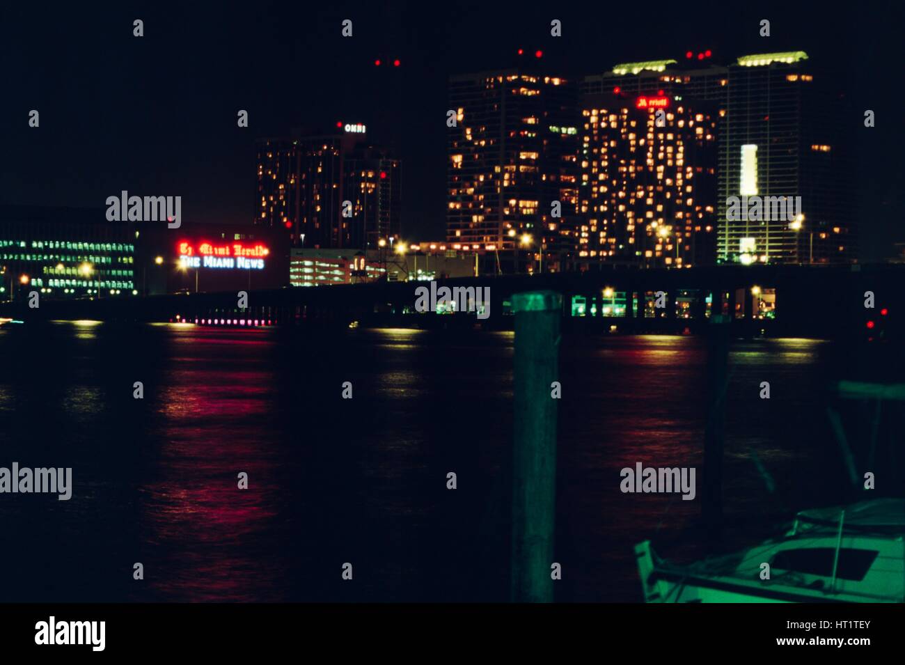 At night, a neon sign is visible on the headquarters building of the Miami Herald newspaper at One Herald Plaza, with the Miami Marriott hotel also visible, Miami, Florida, 1987. Stock Photo