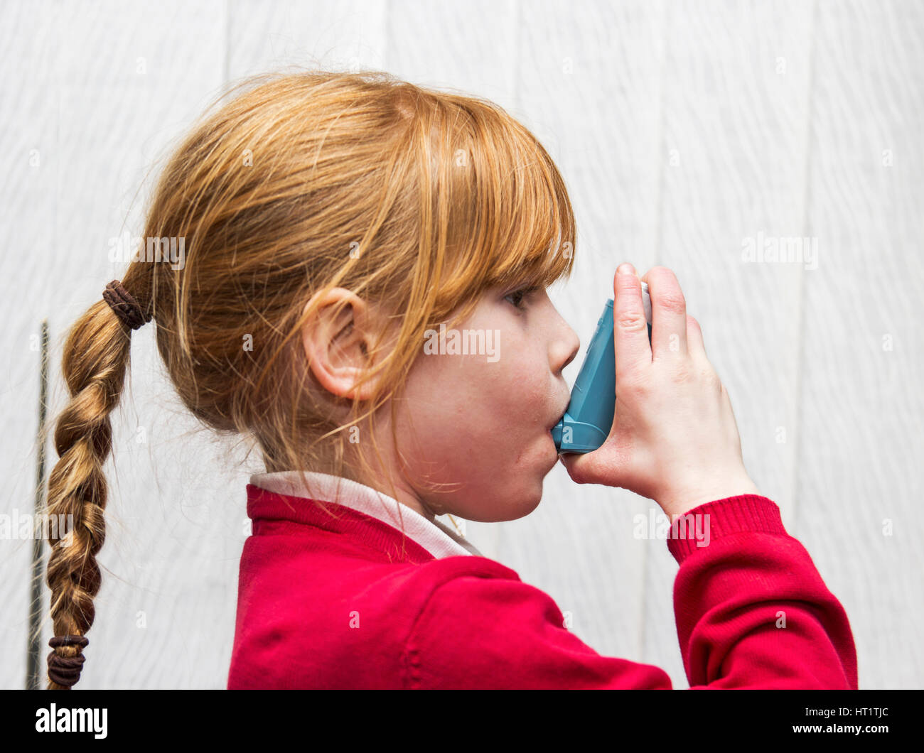 Ventolin asthma inhaler use by 7 year old Caucasian girl Stock Photo